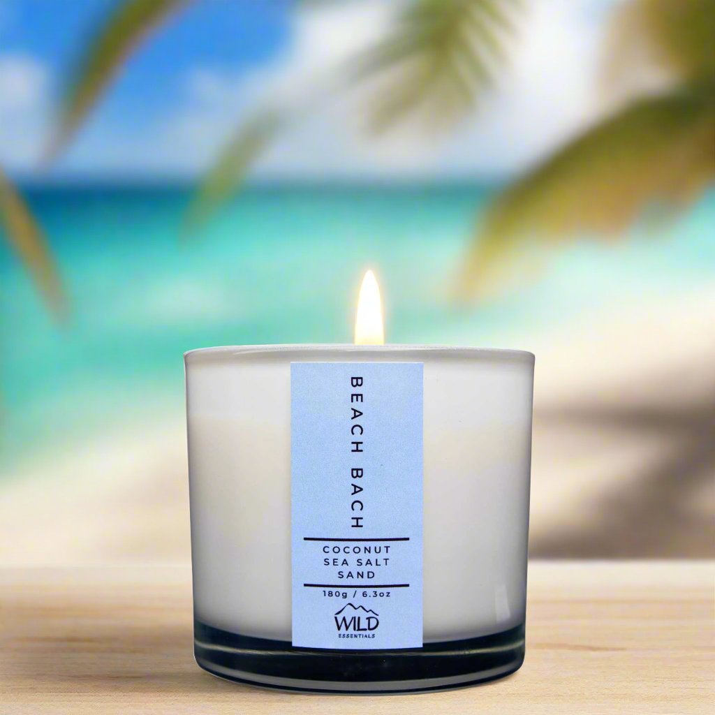 Photograph of the Luxurious Beach Bach Aromatherapy Candle by Wild Essentials with scents of Coconut, Sea Salt, and Sand with background.