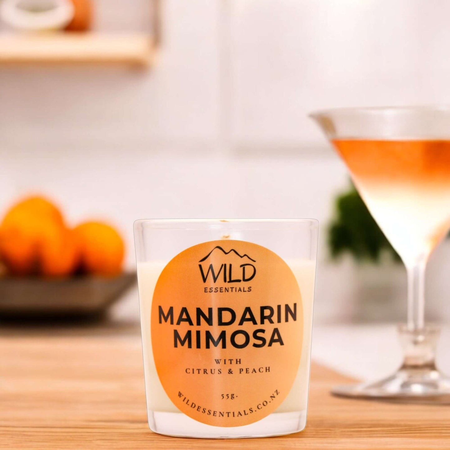 Photograph of the Mandarin Mimosa Mini Candle from Wild Essentials, taken in a modern kitchen.