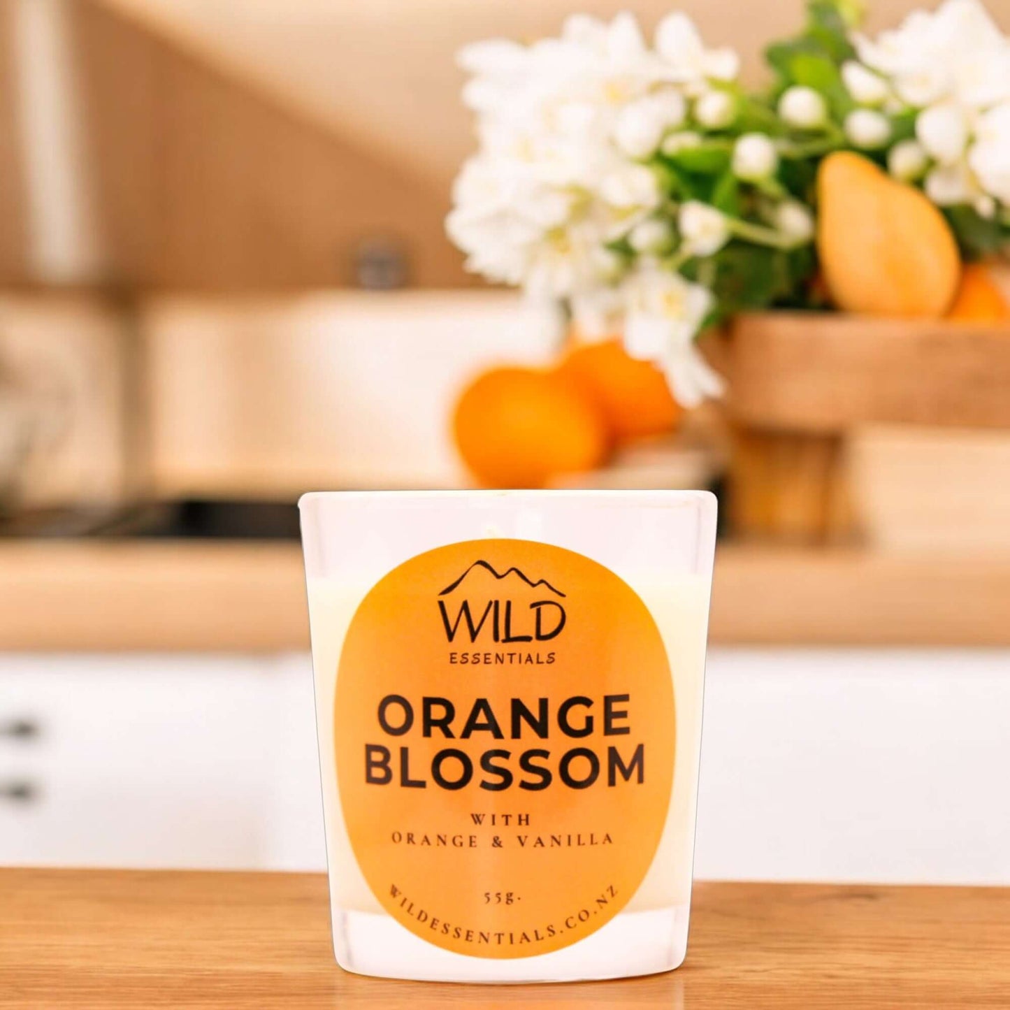 Photograph of the Orange Blossom Mini Candle from Wild Essentials, taken in a modern kitchen.