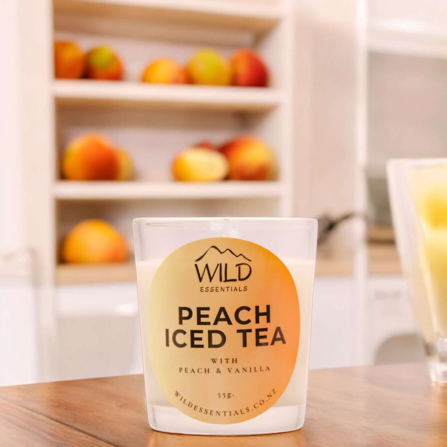 Photograph of the Peach Iced Tea Mini Candle from Wild Essentials, taken in a modern kitchen.