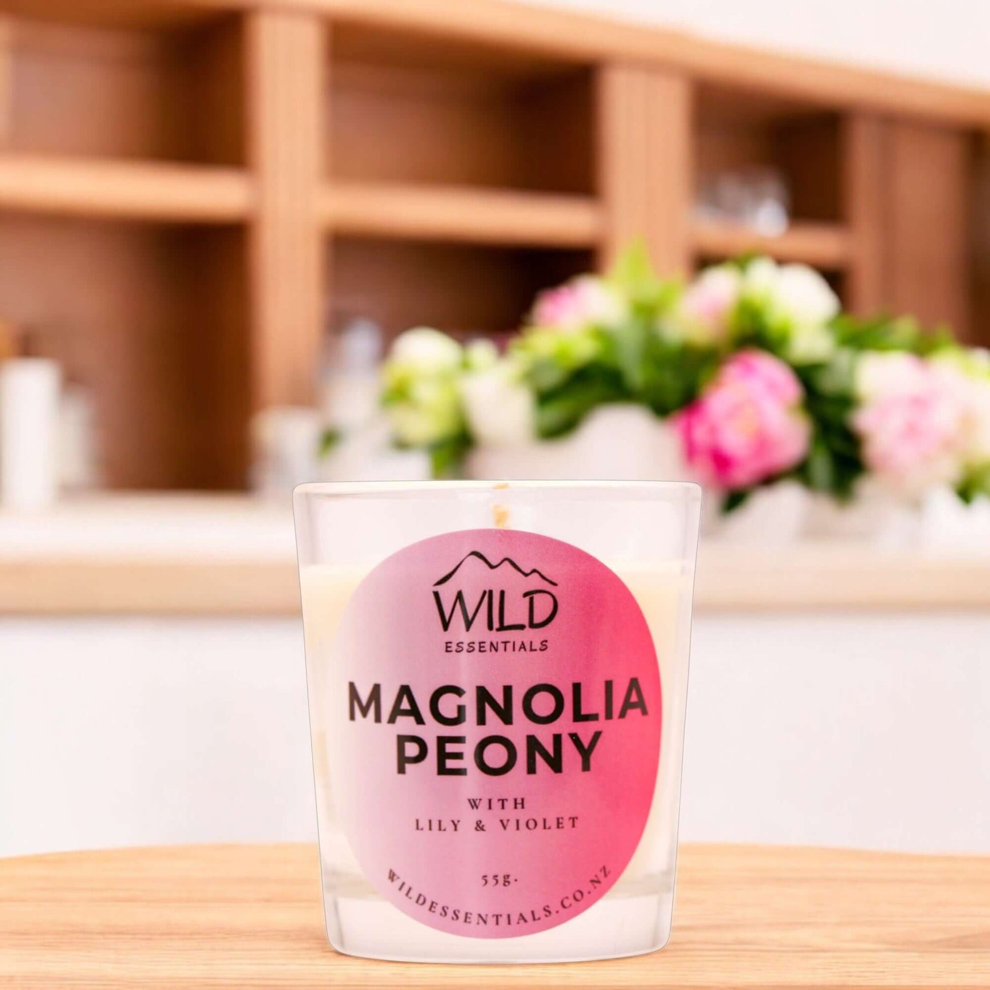 Photograph of the Magnolia Peony Mini Candle from Wild Essentials, taken in a modern kitchen.