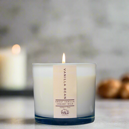 Photo of the Vanilla Bean Luxury Candle from Wild Essentials. The background is blurry.